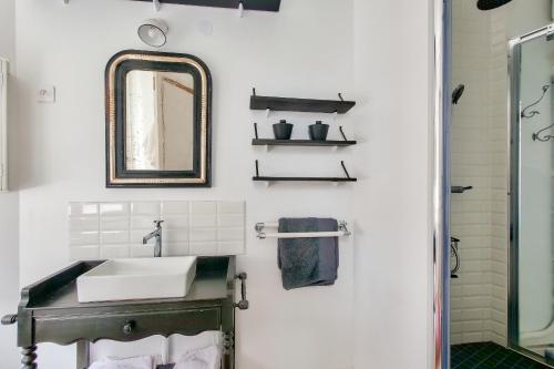 a bathroom with a sink and a mirror at Jolie maison pour 4, aux portes de St Martin de Ré in Saint-Martin-de-Ré