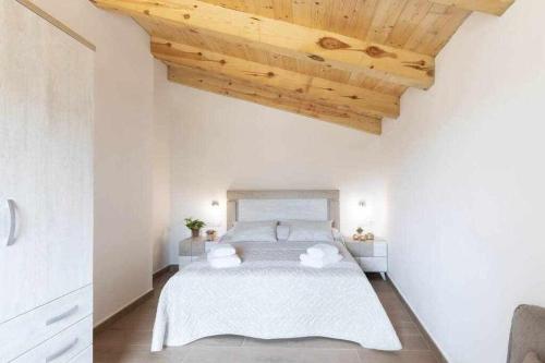 1 dormitorio con 1 cama blanca grande y techo de madera en Apartamentos El Mirador, en Villarroya de los Pinares