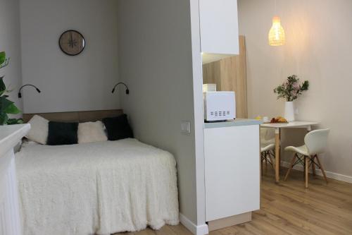 a bedroom with a bed and a table with a laptop at Апартаменты Comfort Life 93 in Almaty