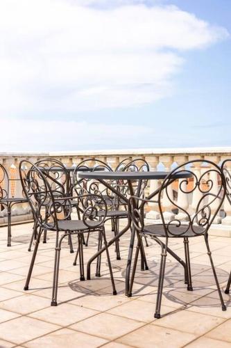 a row of black benches sitting on a balcony at Luxury Accommodation in Santa Domenica