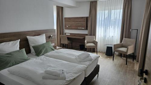 una habitación de hotel con una cama y un escritorio en Landhotel Imhof, en Neuhof