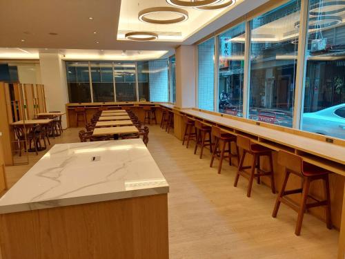 a bar with wooden tables and chairs in a restaurant at 盤古捷旅 - Panco Hotel in Taipei