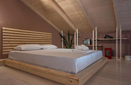 een slaapkamer met een groot wit bed met een houten hoofdeinde bij Villa Manolia in Preveza