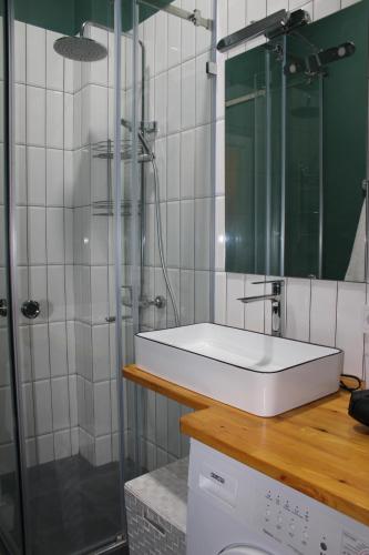 a bathroom with a sink and a glass shower at Апартаменты Comfort Life 93 in Almaty