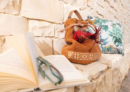 an open book and a purse sitting next to a book at Coppa Carrubo Residenza in Vieste