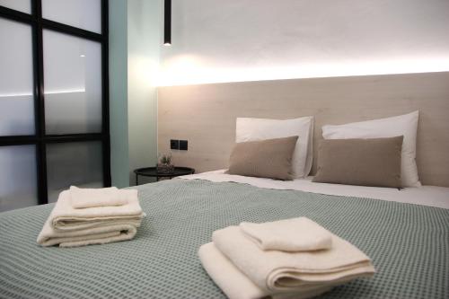 a bedroom with a bed with towels on it at CasaTu 2 Apartments in Komotini