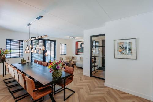 uma sala de jantar e sala de estar com mesa e cadeiras em Brand new bright & luxurious villa in Amsterdam! em Amsterdã