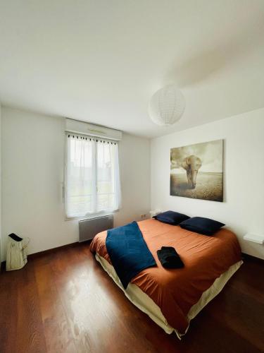 une chambre avec un grand lit et un tableau au mur dans l'établissement Maison entière Domido, à Changé