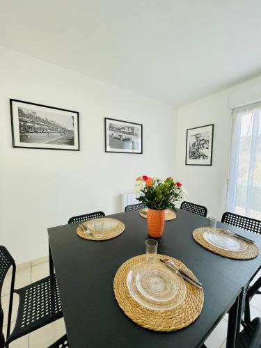 - une table à manger avec des assiettes et des fleurs dans l'établissement Maison entière Domido, à Changé