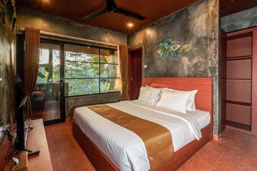 a bedroom with a bed and a large window at Daydream Lodge in Tampaksiring