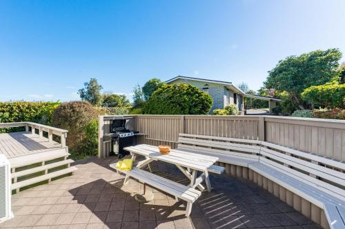 a patio with benches and a table and a grill at Tranquil Retreat in Taupo
