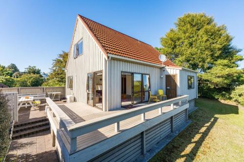 a house with a large deck with a patio at Tranquil Retreat in Taupo