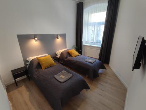 Habitación pequeña con 2 camas y ventana en Apartament Rybaki 22, en Poznan
