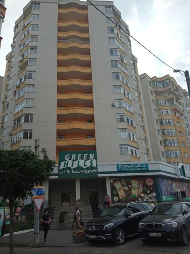 un edificio alto con coches estacionados frente a él en modern home, en Chişinău