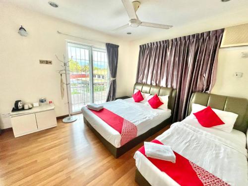 a bedroom with two beds with red pillows at Borneo Inn in Kota Kinabalu