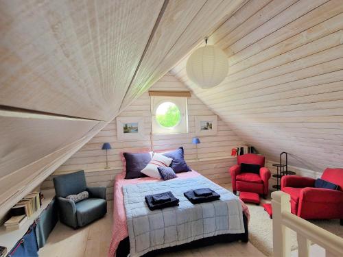 1 dormitorio con 1 cama y sillas en un ático en Les chambres du Keriolet, en La Trinité-sur-Mer