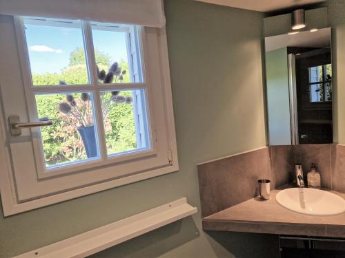 baño con lavabo y ventana en Les chambres du Keriolet en La Trinité-sur-Mer