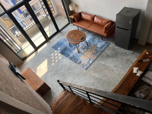 an overhead view of a living room with a couch and a table at liora Cambodia - Riverside Loft Apartments in Phnom Penh