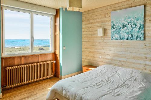 パンマールにあるEchappee relaxante au bord de l ocean a Penmarchのベッドがあり海が見える寝室
