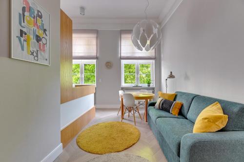 a living room with a blue couch and a table at Apartments Old Town Dluga & by Noclegi Renters in Gdańsk