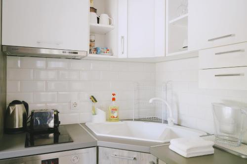 uma cozinha branca com um lavatório e um balcão em Varna city centre - two bedroom apartment em Varna City