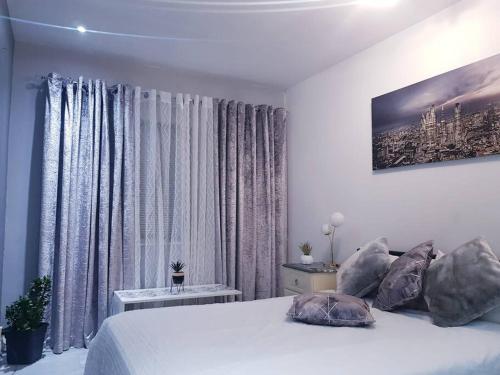 a bedroom with a white bed and a large window at Burburry Studio Apartments in Cleethorpes