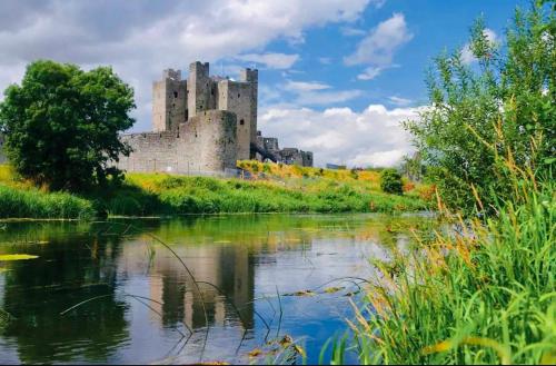 a castle sitting on a hill next to a river at Gems in Ratoath in Ratoath