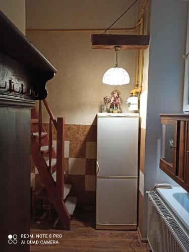 a small kitchen with a refrigerator and a staircase at Kozatski Apartments in Lviv