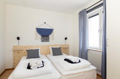 a bedroom with two beds with white sheets at Härnösands folkhögskolas Bed & Breakfast in Härnösand