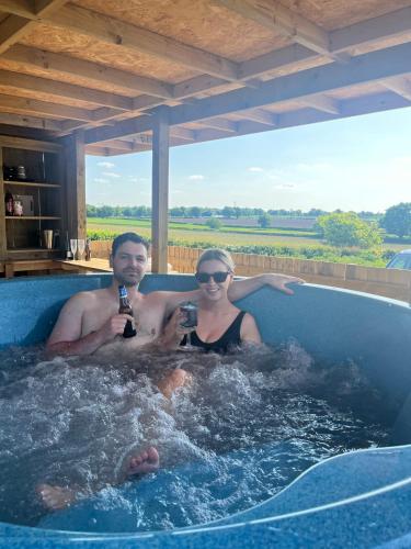 a man and woman in a hot tub with beer at Dukeries Retreat in Retford