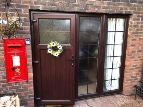 a wooden door with a wreath and a red mail box at Adorable 1 bedroom apartment in Ironbridge in Telford