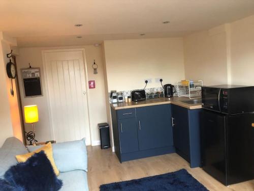 a living room with a kitchen with a blue counter top at Adorable 1 bedroom apartment in Ironbridge in Telford