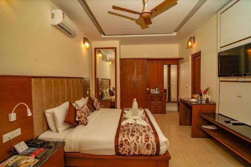 a bedroom with a bed and a flat screen tv at Excel Hotels and Resorts Bhimtal in Bhīm Tāl
