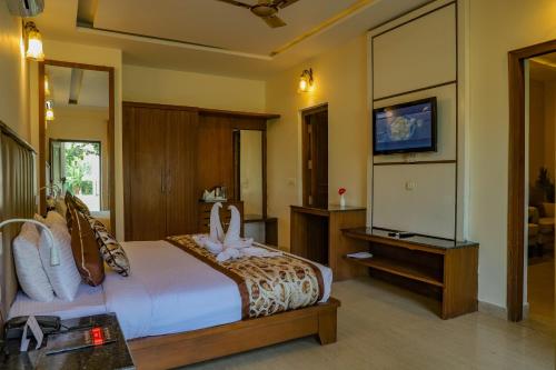 a bedroom with a bed and a television in it at Excel Hotels and Resorts Bhimtal in Bhīm Tāl