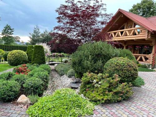 einen Garten mit vielen Büschen und einem Haus in der Unterkunft Kazkova khatynka in Bushtyno