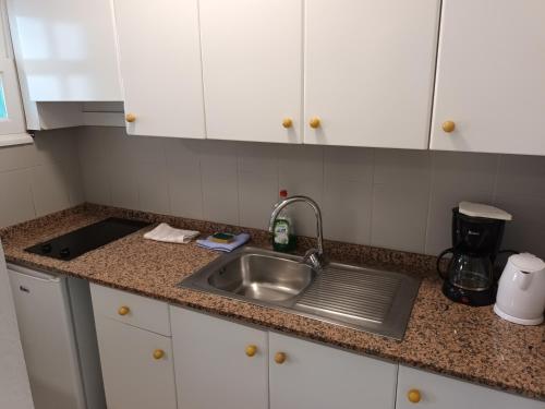 a kitchen counter with a sink and white cabinets at Molino de Guatiza in Costa Teguise