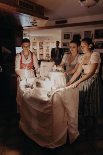 a group of people standing around a table with a cake at Hotel des Glücks - Landhotel Fischl in Sankt Oswald
