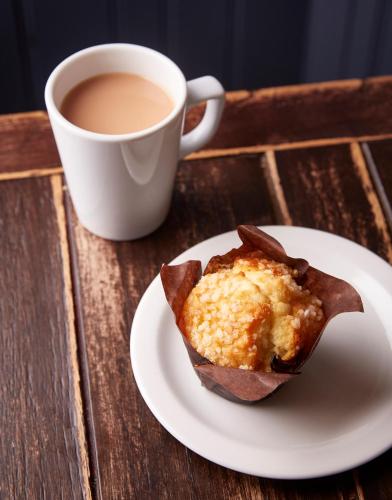 a cup of coffee and a muffin on a plate with a cup of coffee at Victoria Hotel by Chef & Brewer Collection in Menai Bridge