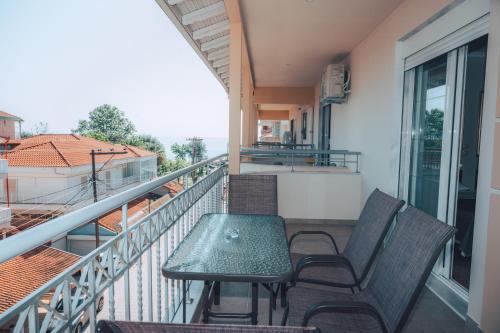 a balcony with a table and chairs on a balcony at Dionysos Rooms in Olympiaki Akti