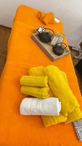 a bed with a yellow towel and a mouse and a plate at da Lilia in Salute&Bellezza in Monfalcone