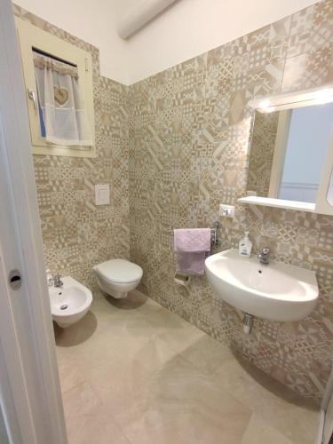a bathroom with two sinks and a toilet at Le Casette di Adele in Palagiano