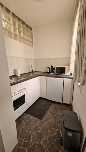 a small kitchen with white cabinets and a sink at W.I.L.A. in Helmbrechts