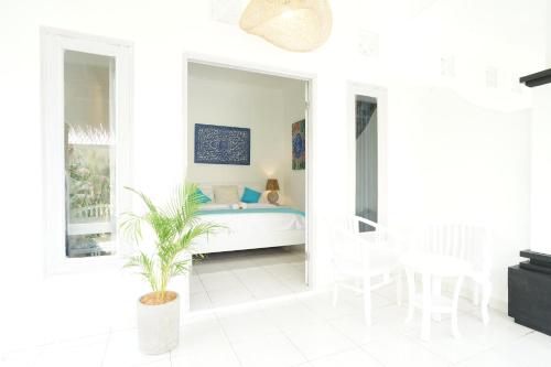 a bedroom with a bed and a table and chairs at Sukacita Hill in Uluwatu
