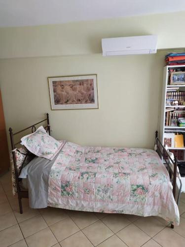 Un dormitorio con una cama con una manta. en Άνετο studio σε πολυκατοικία στην Άνω Γλυφάδα en Athens