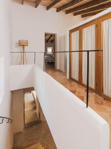 a staircase in a room with white walls and wooden ceilings at Llucamar Villa in Sant Llorenç des Cardassar