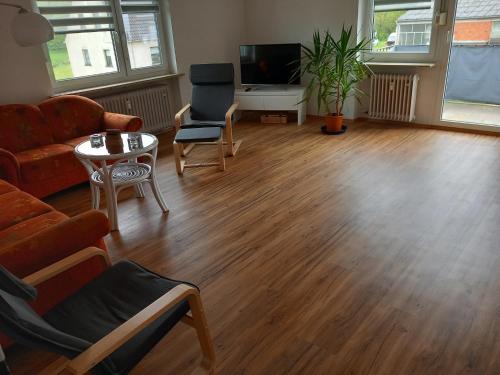 salon z kanapą i stołem w obiekcie Ferienwohnung am Waldrand w mieście Bechhofen