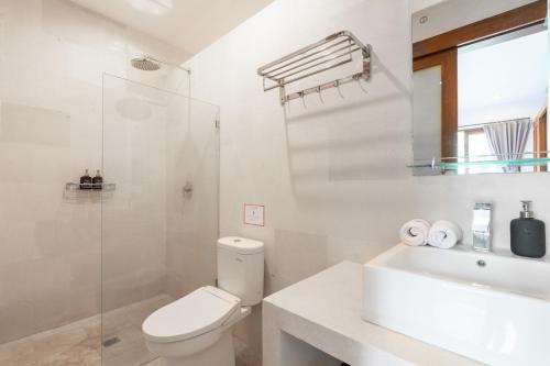 a white bathroom with a toilet and a sink at Du Ciel Villa by Hombali in Canggu