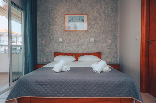 a bedroom with a bed with two pillows at Dionysos Rooms in Olympiaki Akti