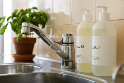 a sink with two bottles of soap and a faucet at Härnösands folkhögskolas Bed & Breakfast in Härnösand