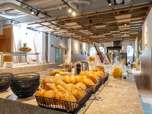 a counter with baskets of bread and pastries on it at ibis Styles Graz Messe in Graz